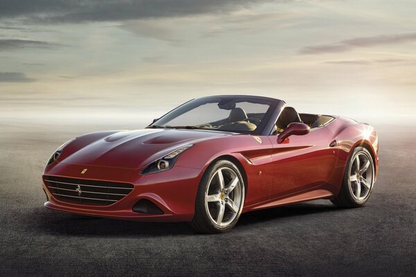Coche deportivo de lujo de color rojo contra el cielo brumoso. Elegante Ferrari rojo sobre un fondo gris brumoso