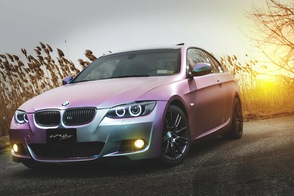 Voiture de sport de marque BMW sur fond de champ au coucher du soleil