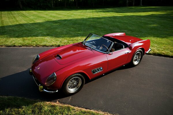 Viejo Ferrari rojo convertible en el césped