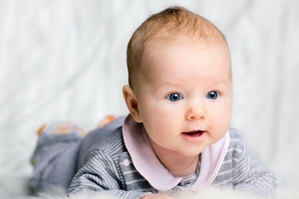 Bébé garçon aux yeux bleus en pyjama rayé
