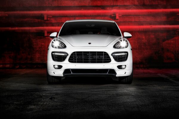Blanc Porsche Cayenne dans l obscurité avec un rétro-éclairage rouge sur un fond sans tuyaux