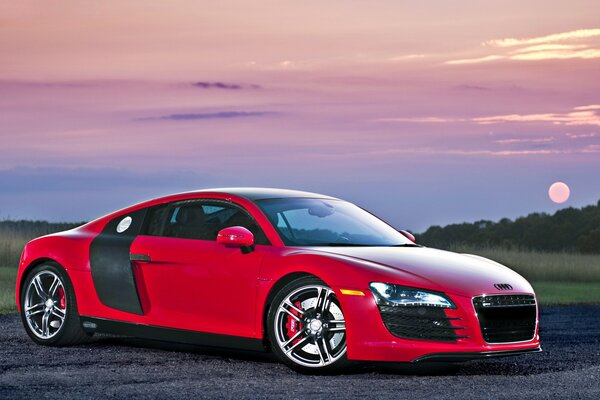 Hermoso coche en el fondo de una brillante puesta de sol
