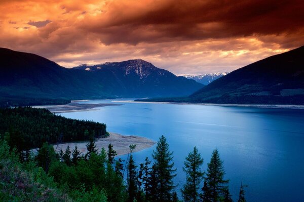 Blue lake surrounded by mountains at sunset