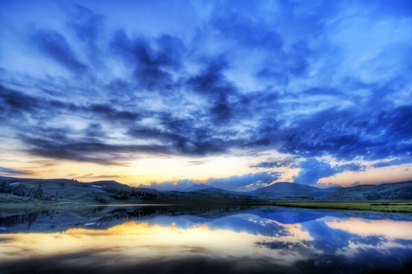 A light fog descended on the mountains and forest, reflecting the clouds in the lake
