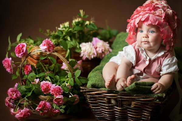 Photo drôle de bébé avec des fleurs et un panier