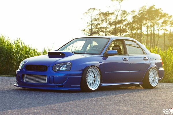 Tuned blue Subaru on the background of nature