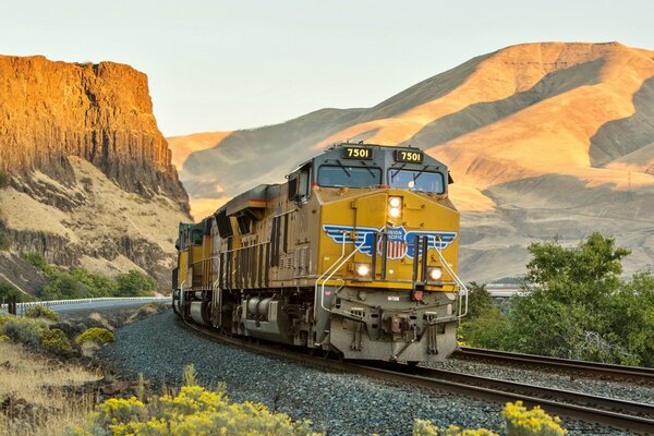 La locomotive se déplace sur les rails parmi les montagnes majestueuses