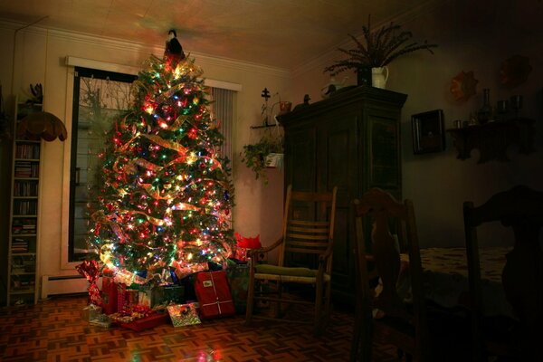 Grand arbre de Noël avec des cadeaux dans la chambre