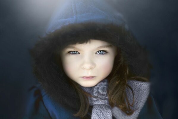 Portrait d un enfant aux yeux bleus dans une capuche bleue