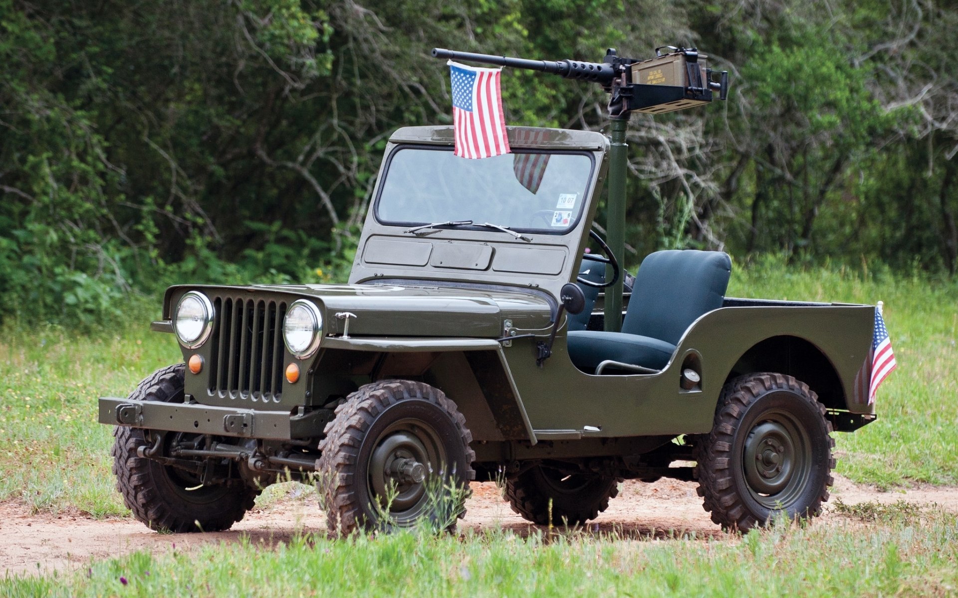 jeep m38 jeep 1950 jeep.suv frente bandera hierba árboles fondo