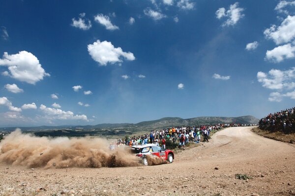 Zuschauer bei der Rallye beobachten den Citroen beim Abbiegen