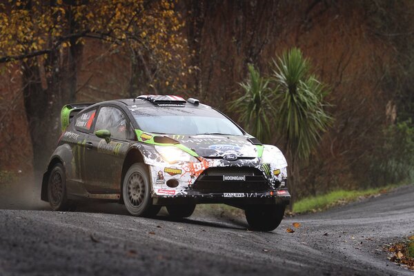 Racing car Ford fiesta rally rides along the road along the forest