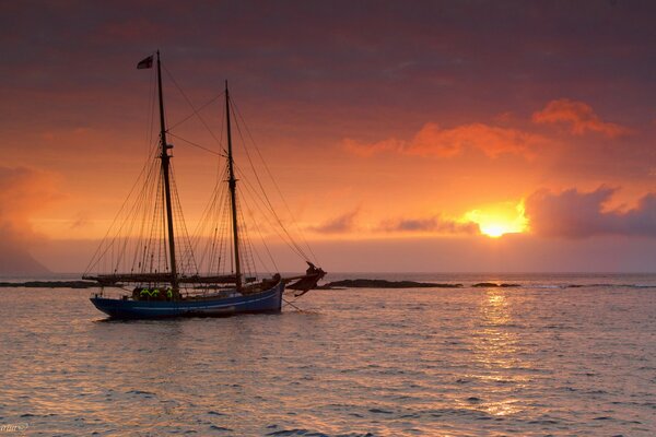 The yacht sails on the sea at sunset