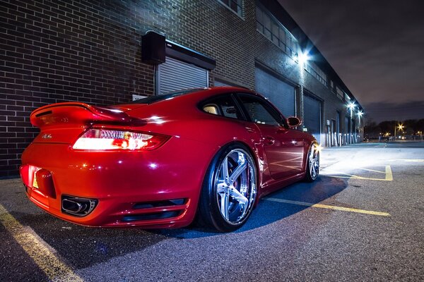 A red Porsche car on the background of a garage