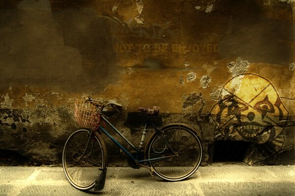 Rower z koszem na tle ściany i rysunkiem przerażającego klauna