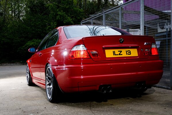 Rear view of a red BMW car. With a yellow license plate