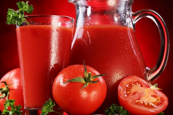 Roter Tomatensaft in Glas und Krug