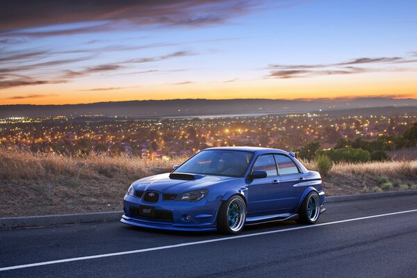 Blue Subaru impreza with beautiful tuning on the background of the morning sky