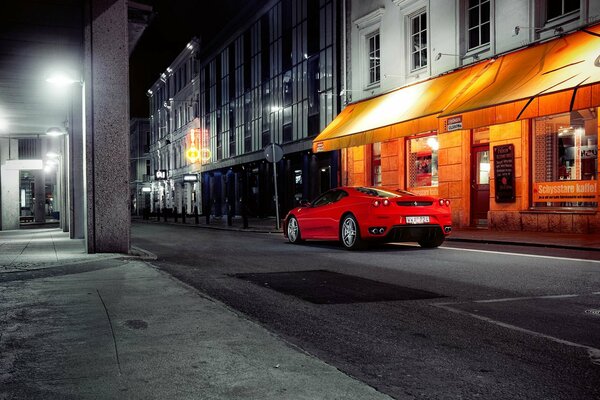 Czerwone Ferrari przy nocnych gablotach