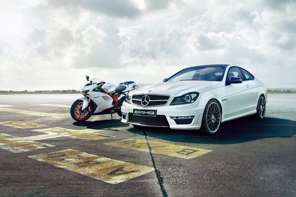 Coche blanco y moto contra el cielo