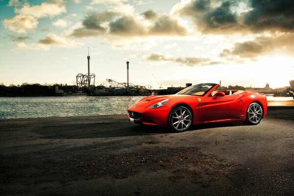 Coche Ferrari California en el muelle junto al río