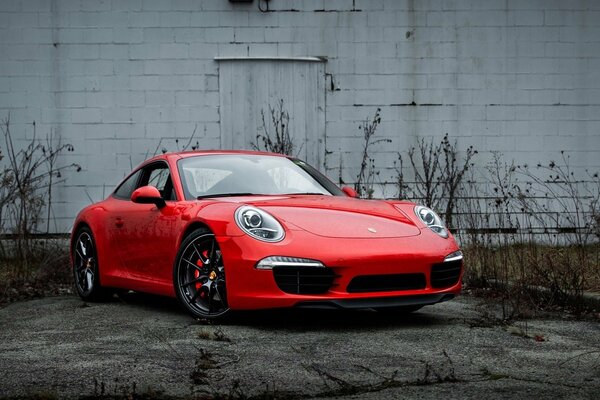 Rotes Porsche-Auto auf Wandhintergrund