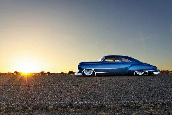 Chevrolet bleu classique au coucher du soleil