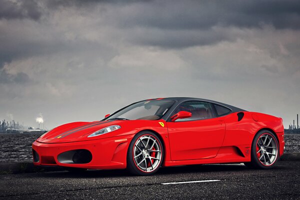 A chic red Ferrari on the background of the factory