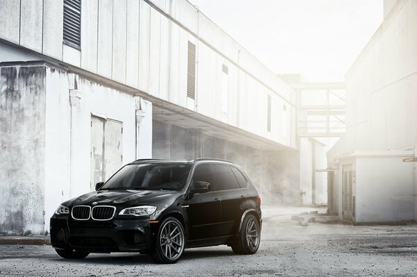 BMW negro en la neblina en el fondo del edificio