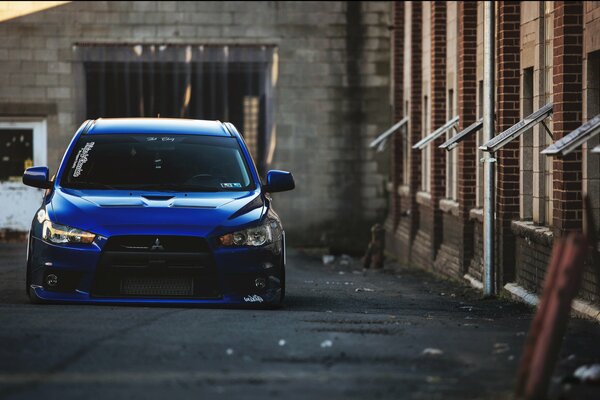 A blue mitsubishi car stands on the territory of the plant