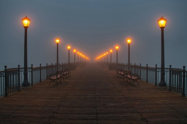 Muelle desierta y luces encendidas en la niebla