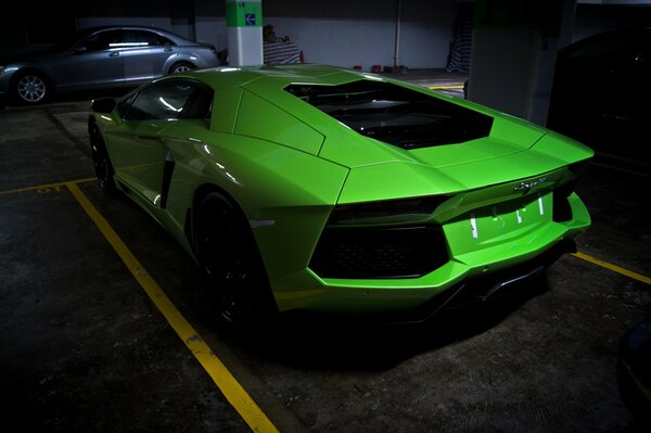 There is a green car in the parking lot