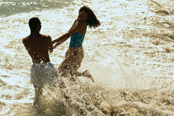 A joyful couple in the water with splashes