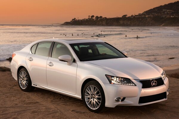 Lexus gs450h sur la plage au coucher du soleil