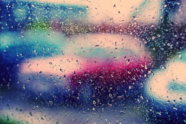 Coches detrás del vidrio durante la lluvia