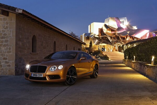 A bronze Bentley, at dusk with a blue sky