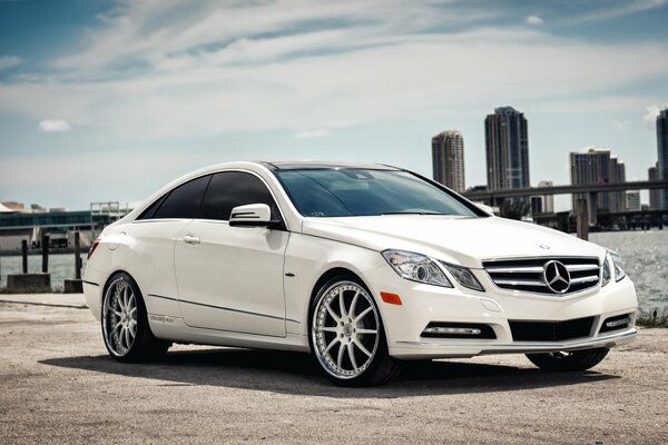 Mercedes benz e-class coupé blanco en el fondo de los rascacielos