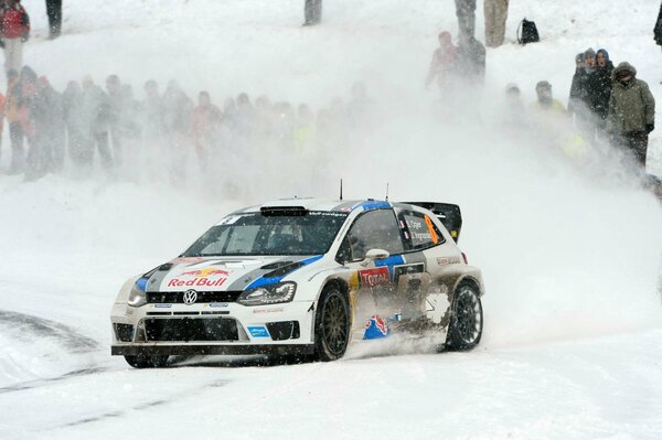 A sports car covered onlookers with snow