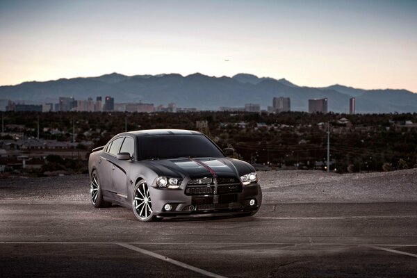 Against the background of the city and the mountains there is a car