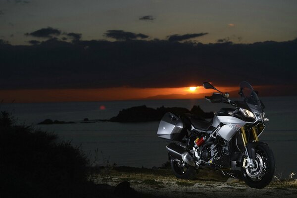 Moto, aprilia caponord 1200 sur fond de coucher de soleil