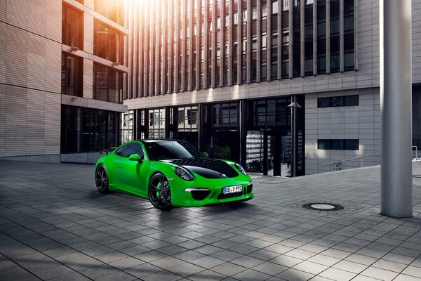 Green car on the background of buildings