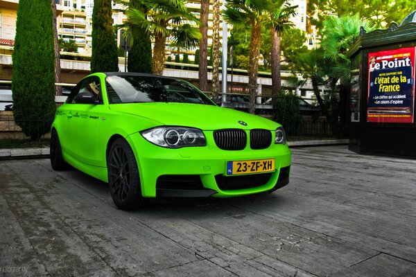 Зеленый BMW m1 купе зеленого цвета во Франции на фоне деревьев