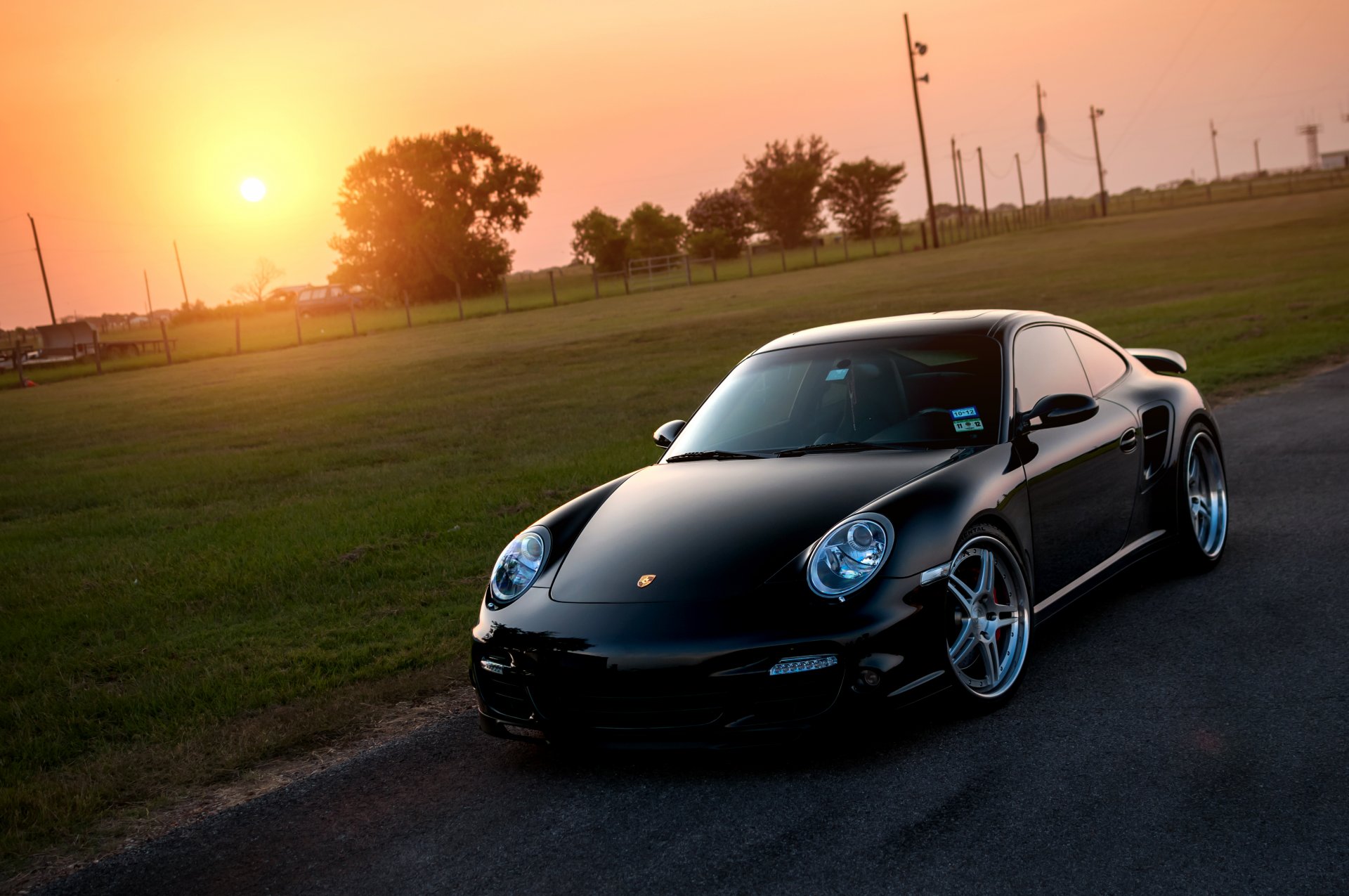 porsche 911 turbo noir avant porsche soleil pelouse éblouissement