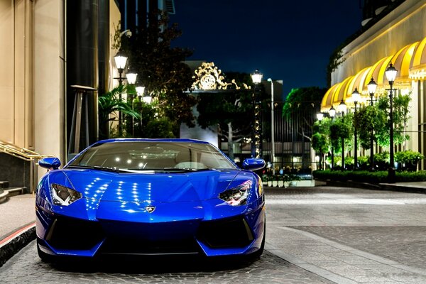 Blue Lamborghini on a night street on a background of lanterns