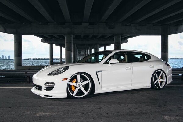 Weißer getunter Porsche Panamera mit schönen Felgen, Foto unter der Brücke