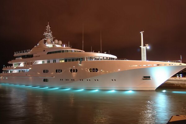 Yate blanco en el muelle contra el cielo nocturno