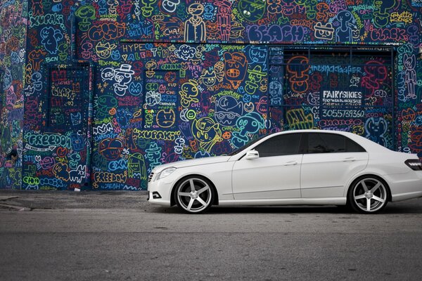 Weiß, Mercedes seitlich auf Graffiti-Hintergrund