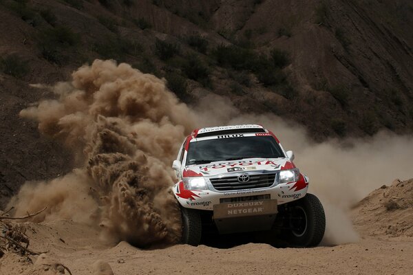 Toyota SUV effectively enters the turn, leaving behind clouds of dust