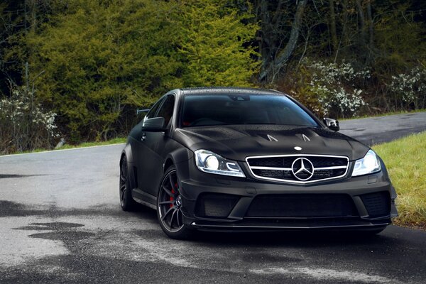 Black Mercedes C63 on wet asphalt