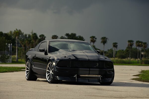 Tinted car against dark clouds